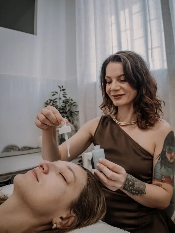 Mayara Mazzoni a aplicar um sérum no rosto de uma cliente, em Almada